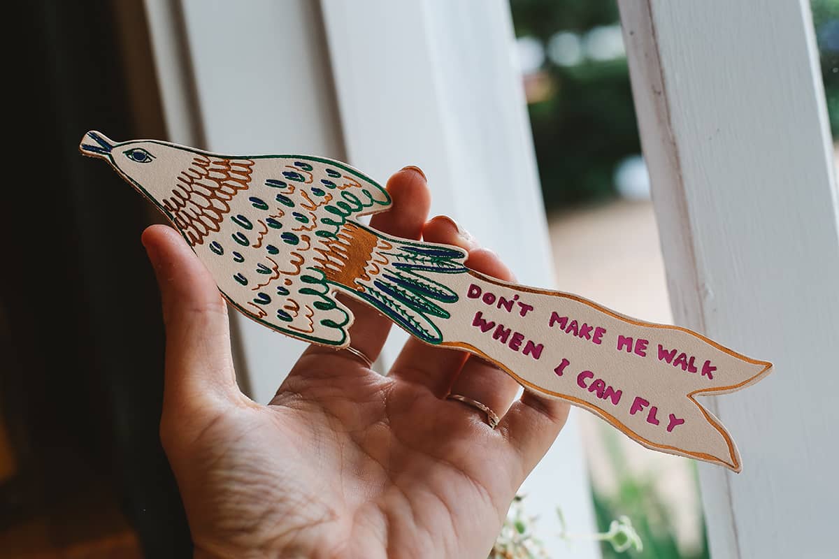 Àine & Co. Ark Bookmark in bird, featuring illustrated gold and green bird with graphic text "Don't make me walk when I can fly"