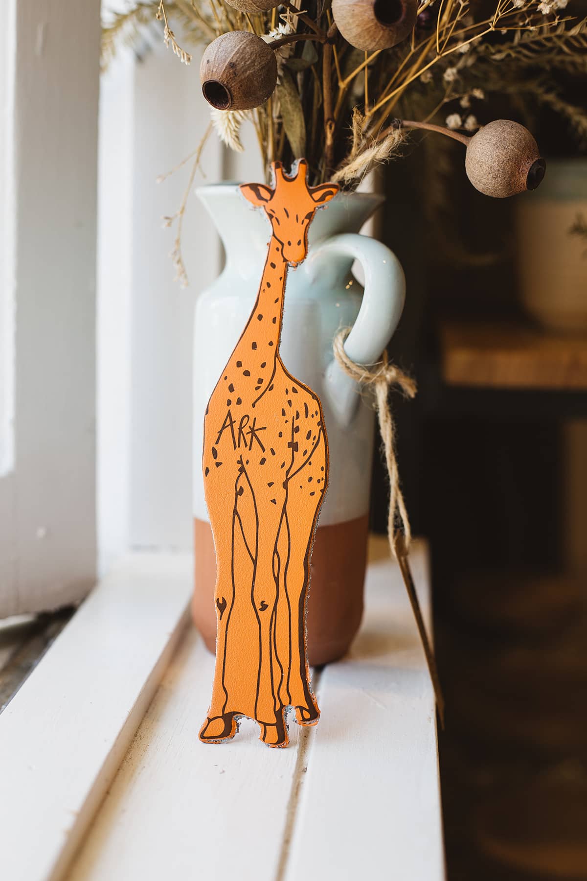 Àine & Co. Ark Bookmark in Giraffe, featuring orange and brown giraffe design and signature "Ark"
