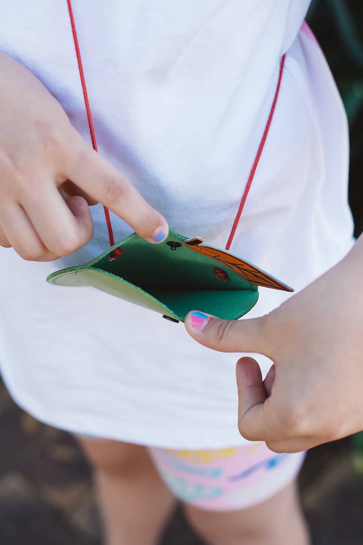 Àine & Co. Ark leather crossbody Coin Purse in Apple, featuring green apple with pink worm design and snap button closure