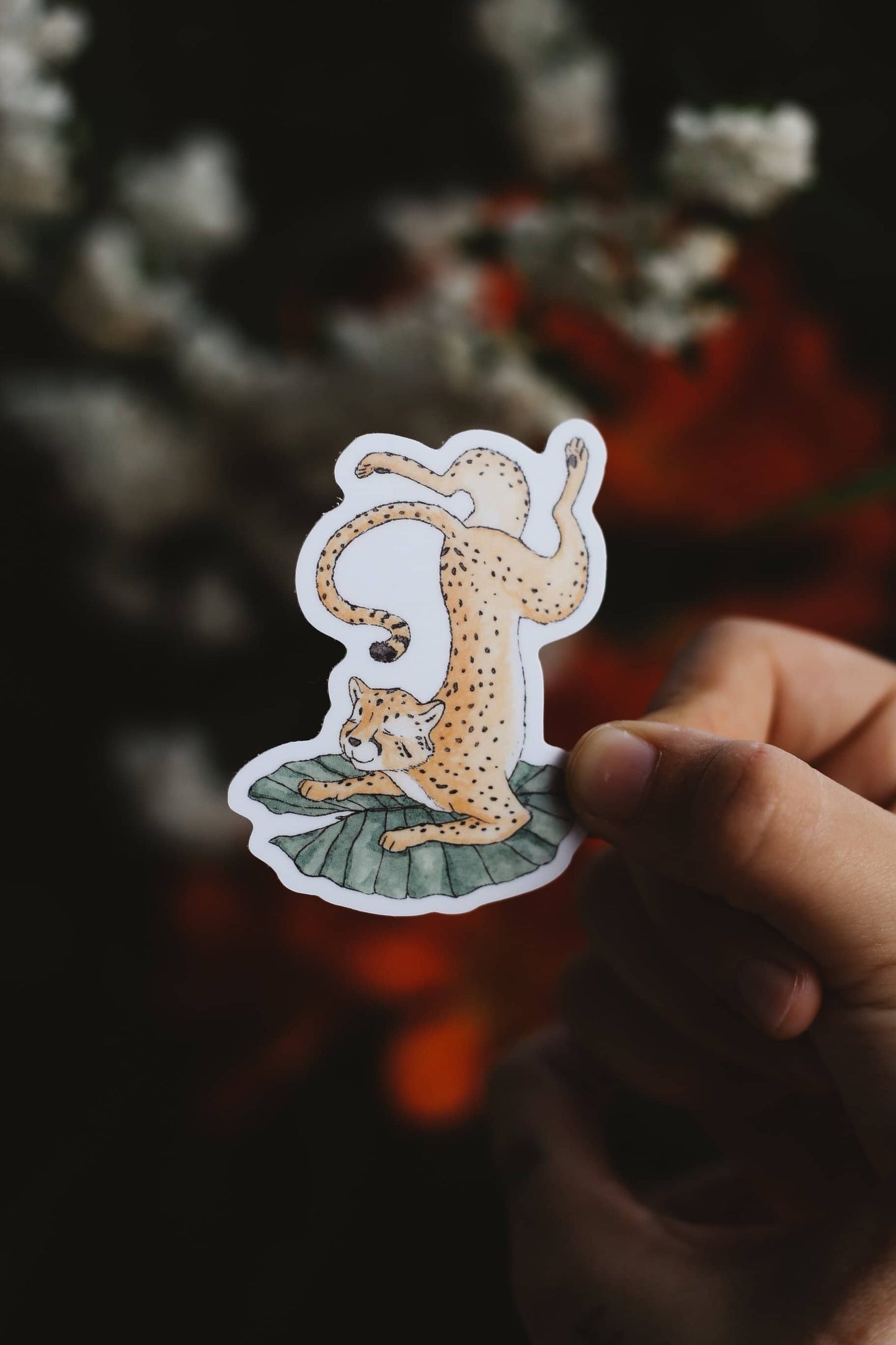 Hand holding a sticker of a cheetah on a lilypad