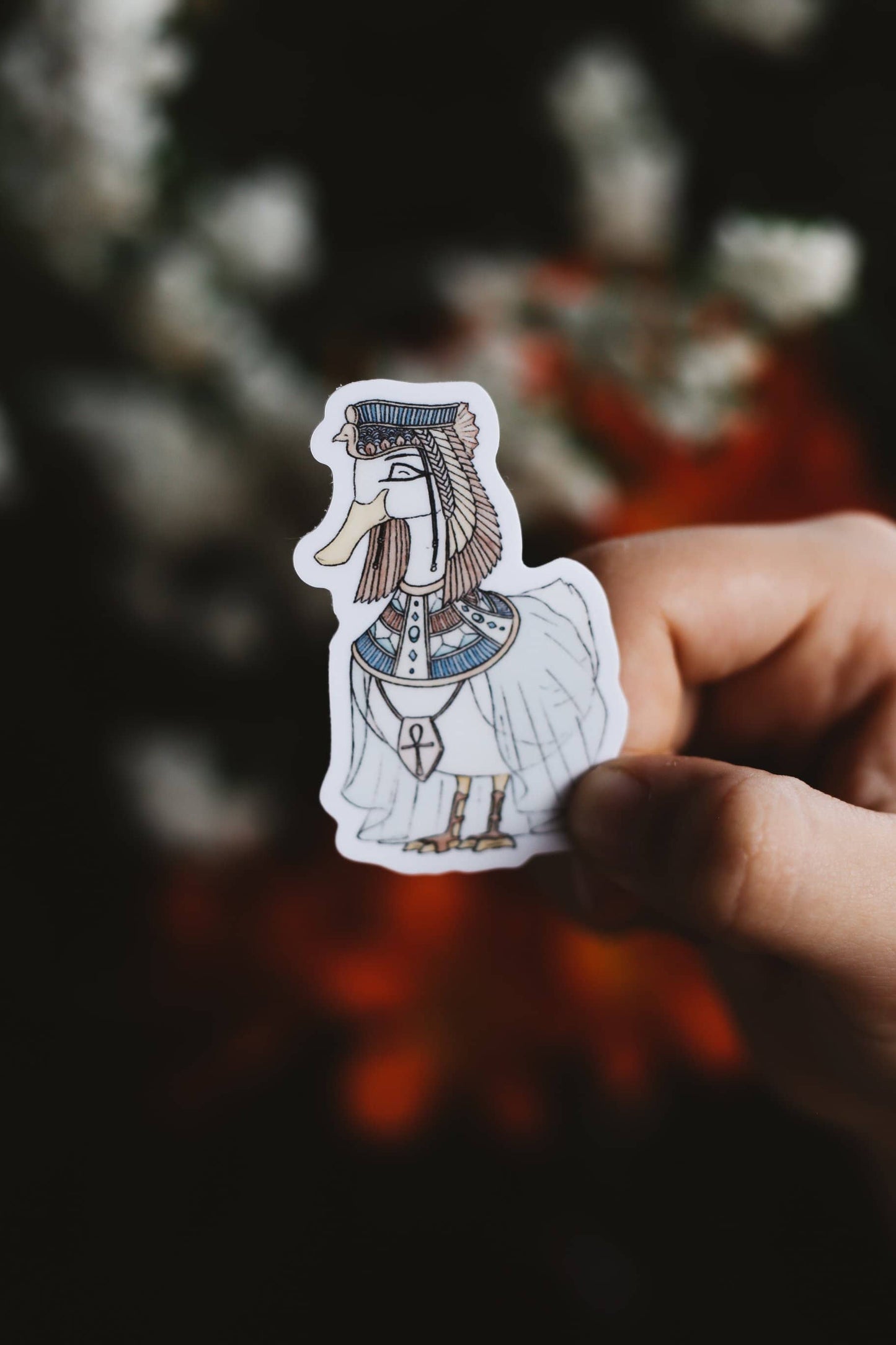 Hand holding a sticker of a duck in Egyptian attire