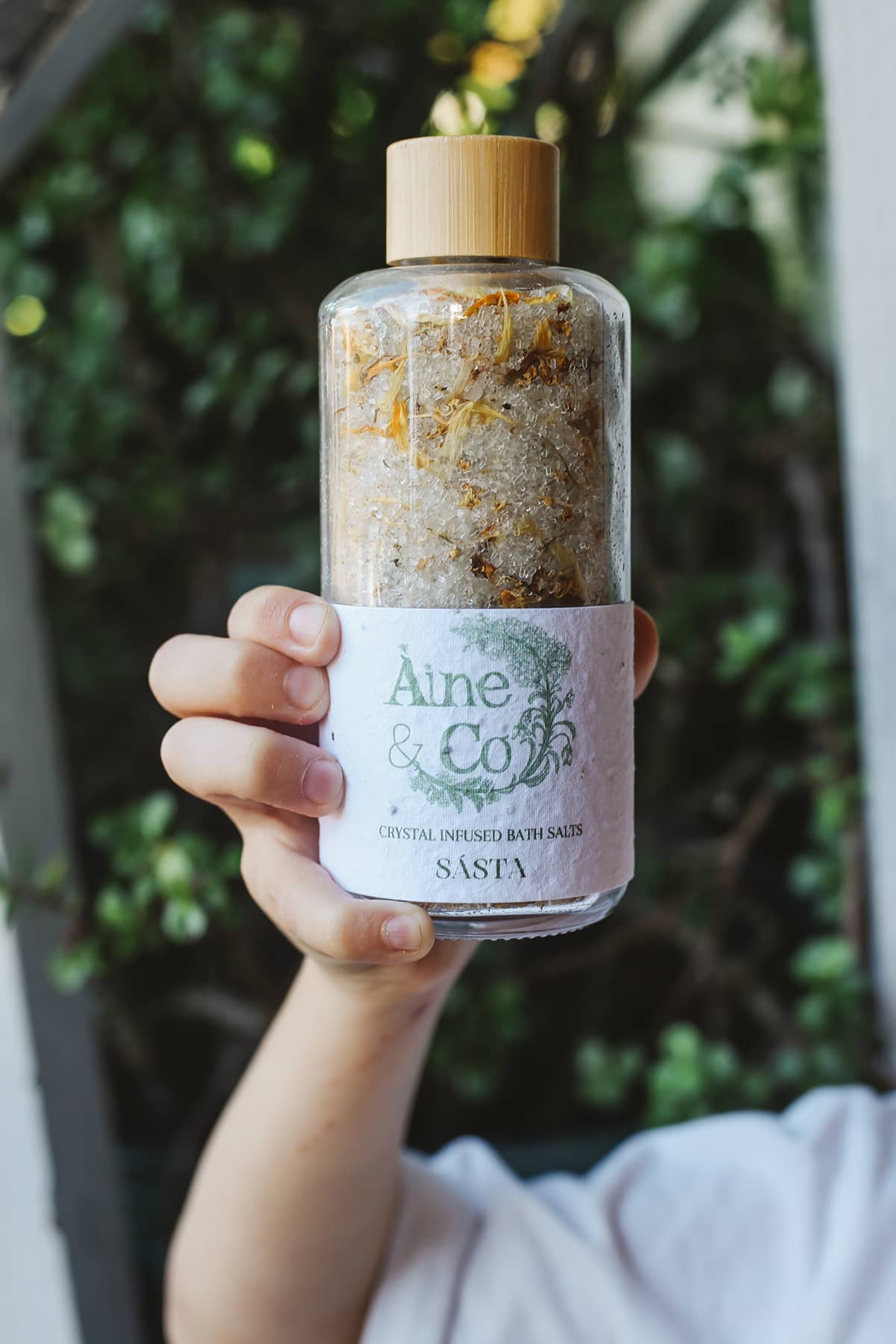 Àine & Co. Crystal Infused Bath Salts in Sásta, packaged in glass bottle with wooden lid