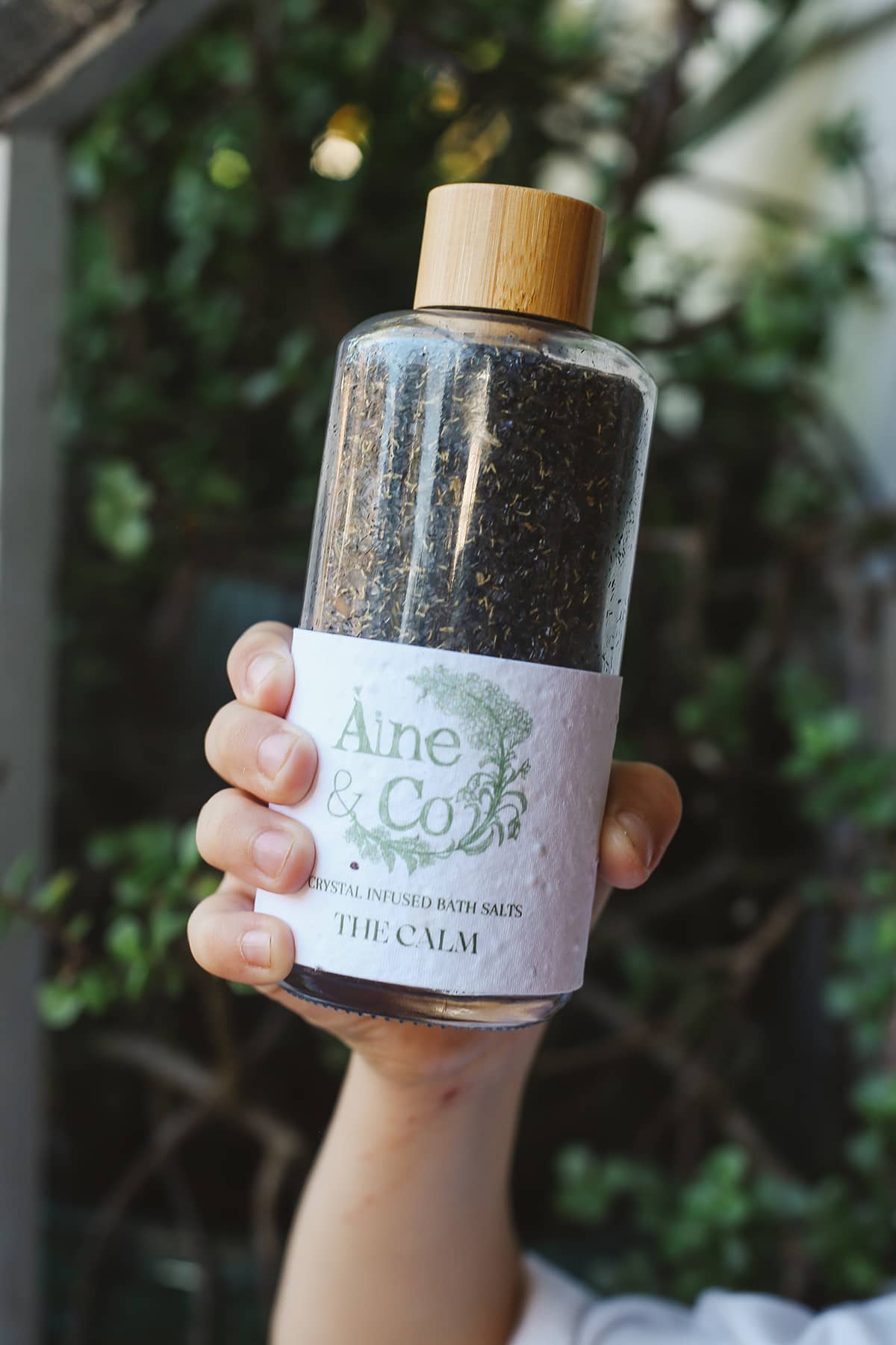 Àine & Co. Crystal Infused Bath Salts in The Calm, packaged in glass bottle with wooden lid