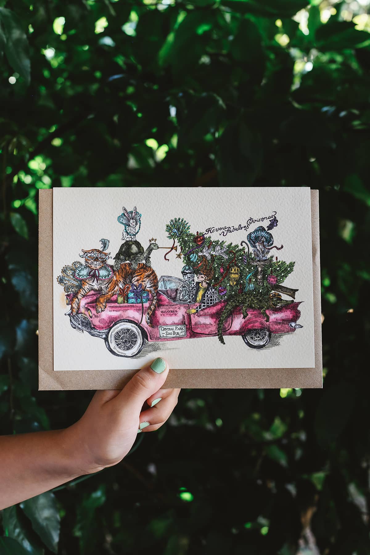 Gisela Greeting Card in "Pink Christmas" featuring an intricate illustration ofanimals in a pink convertible car with a Christmas tree in the back