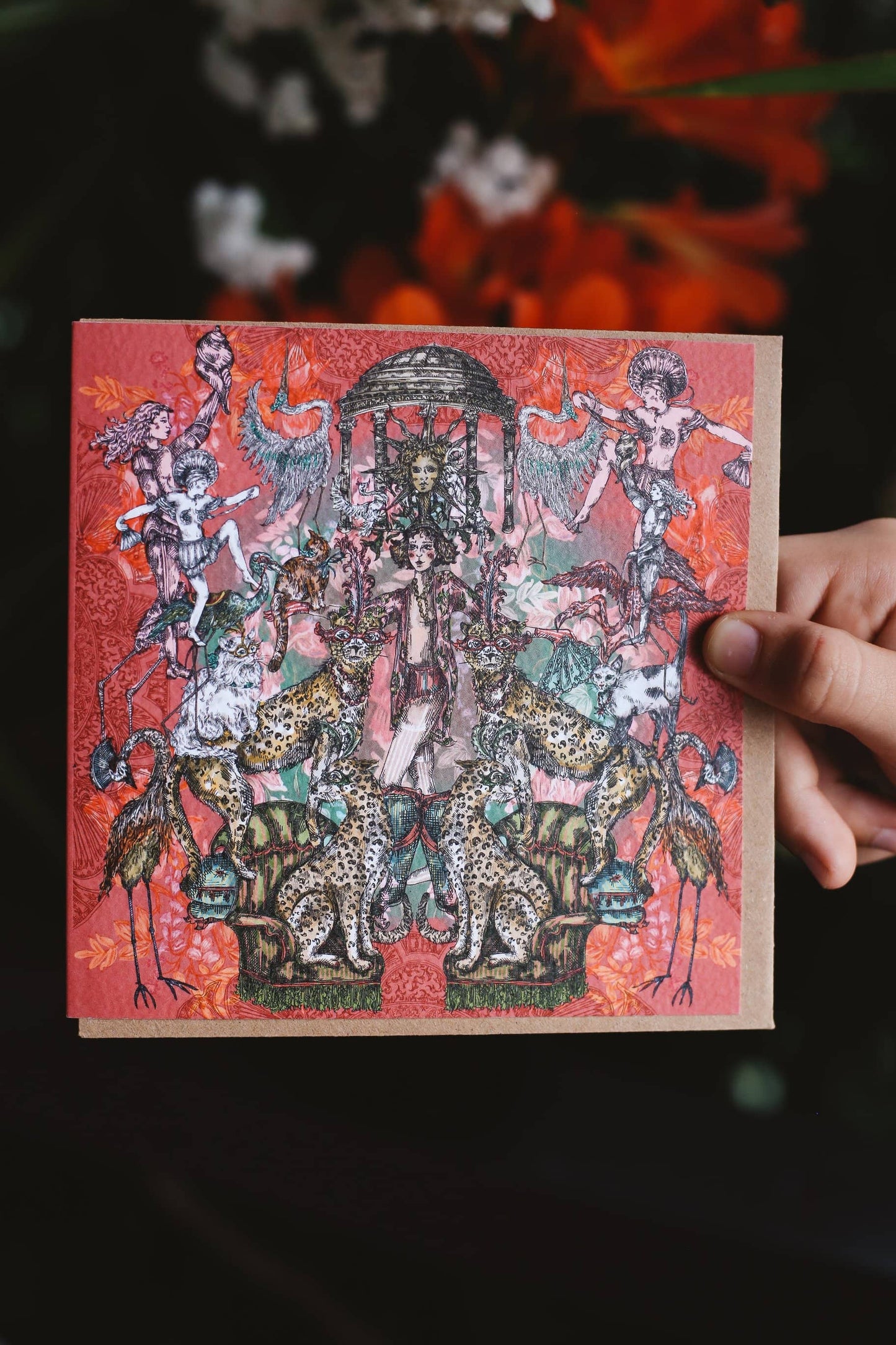 Decorative card with intricate designs of woman surrounded by various cats, cheetahs and leopards on a red background