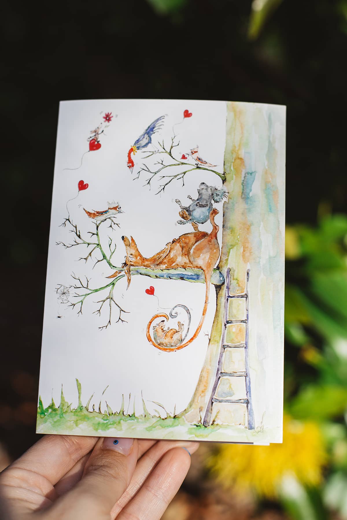 Àine & Co. gift card by Australian Artist, Heather Dale, featuring illustrated Australian wildlife relaxing by a tree, surrounded by little love hearts