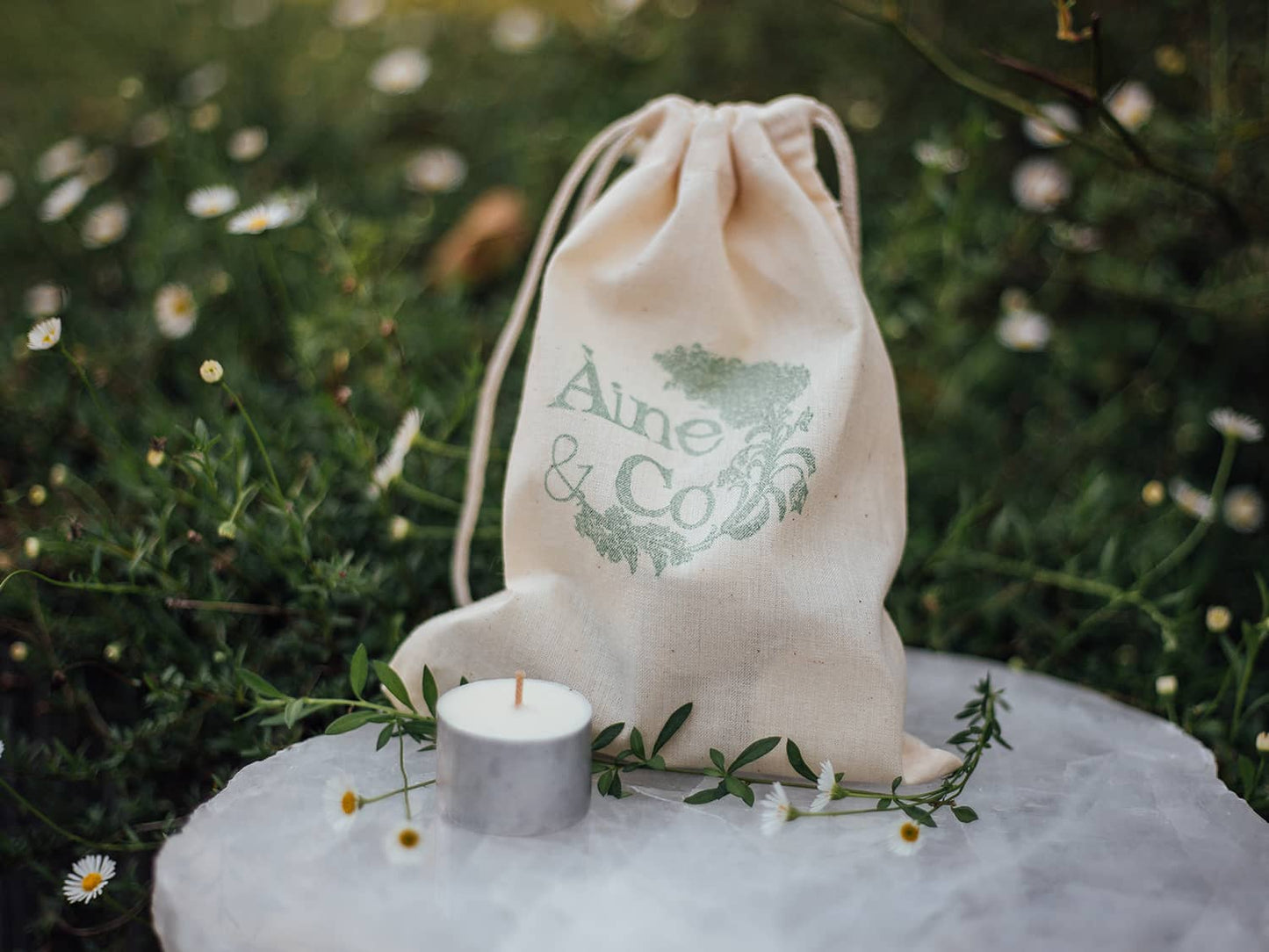 An Àine & Co. Tea Light, shown with the Àine & Co. calico drawstring bag