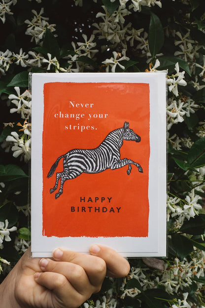 Àine & Co. Archivist greeting card featuring zebra on orange background with text "Never change your stripes. Happy Birthday"