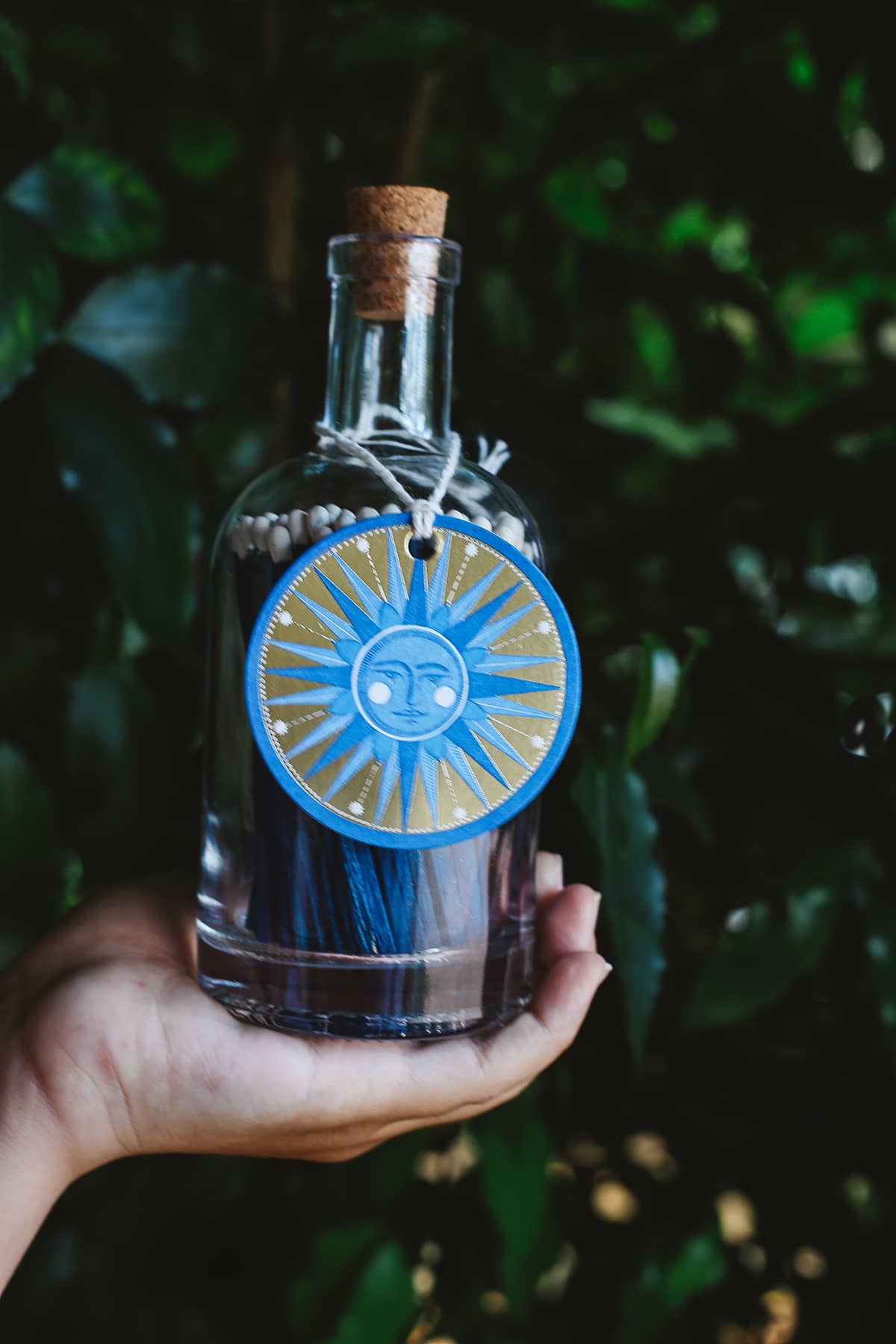 Archivist Match Bottle featuring long navy blue matches in a corked glass bottle with a blue illustrated sun design gift tag