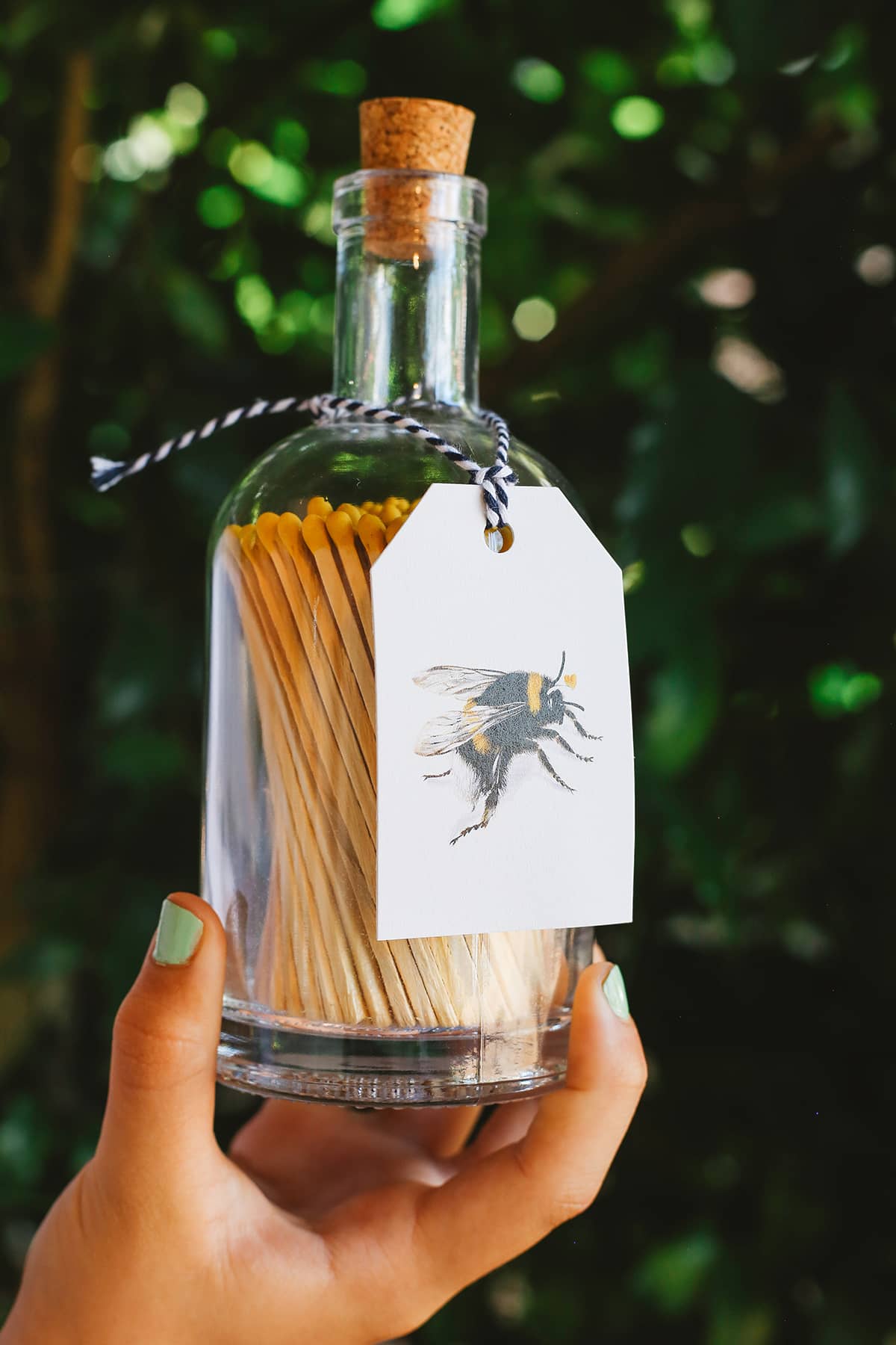 Archivist Match Bottle featuring long orange matches in a corked glass bottle with a bee design gift tag