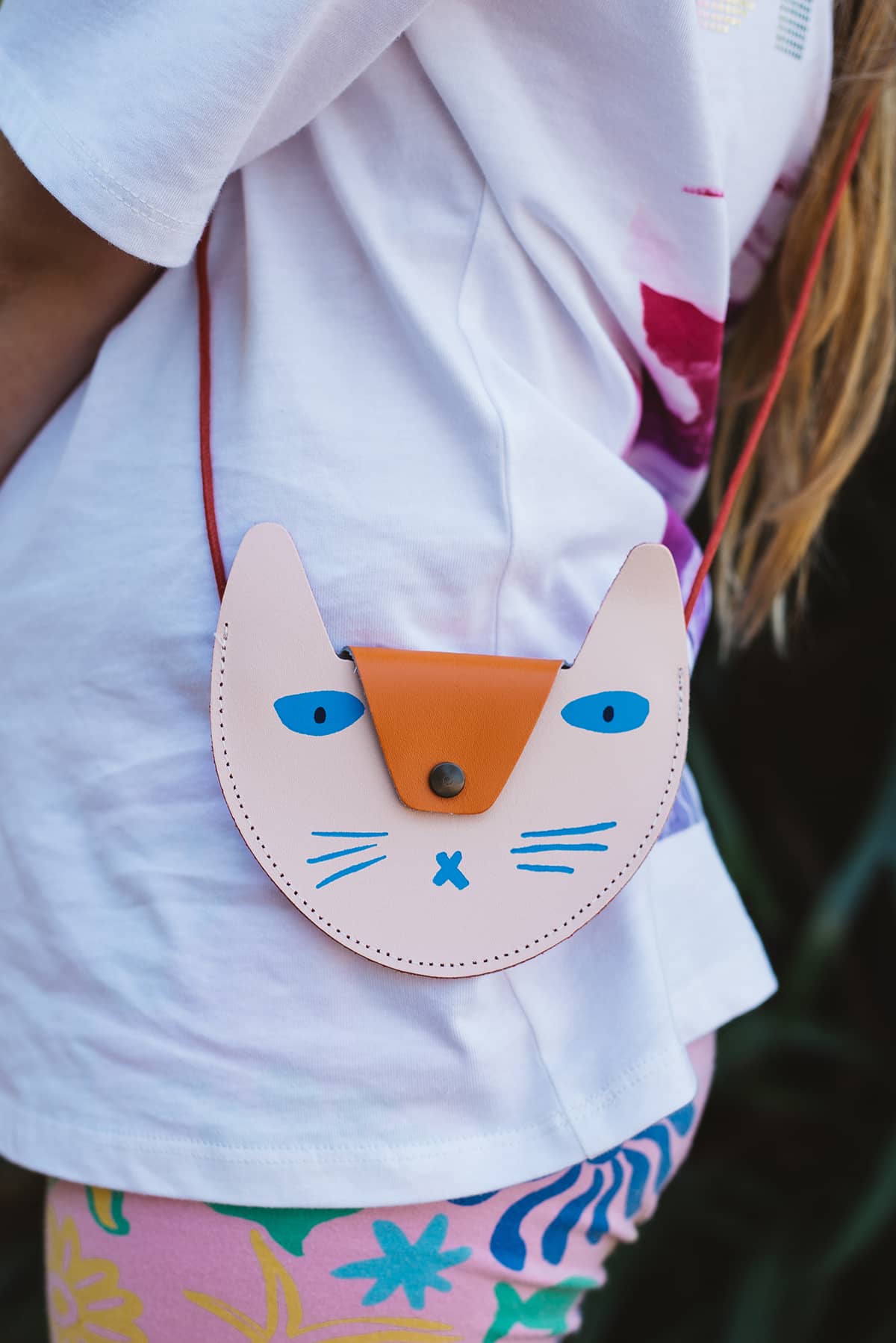 Àine & Co. Ark leather crossbody Coin Purse in Orange Cat, featuring orange cat and blue facial features design and snap button closure
