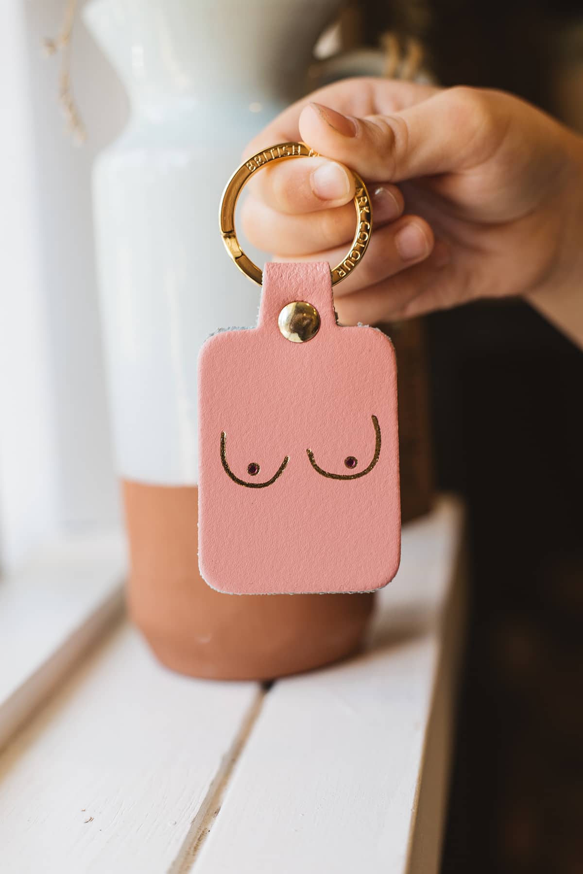 Àine & Co. Ark Colour Design Keyring in "Female (Pink)", featuring leather with illustrated breast design and gold hardware