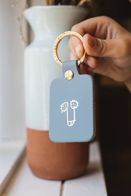 Àine & Co. Ark Colour Design Keyring in "Male (Grey)", featuring leather with illustrated breast design and gold hardware