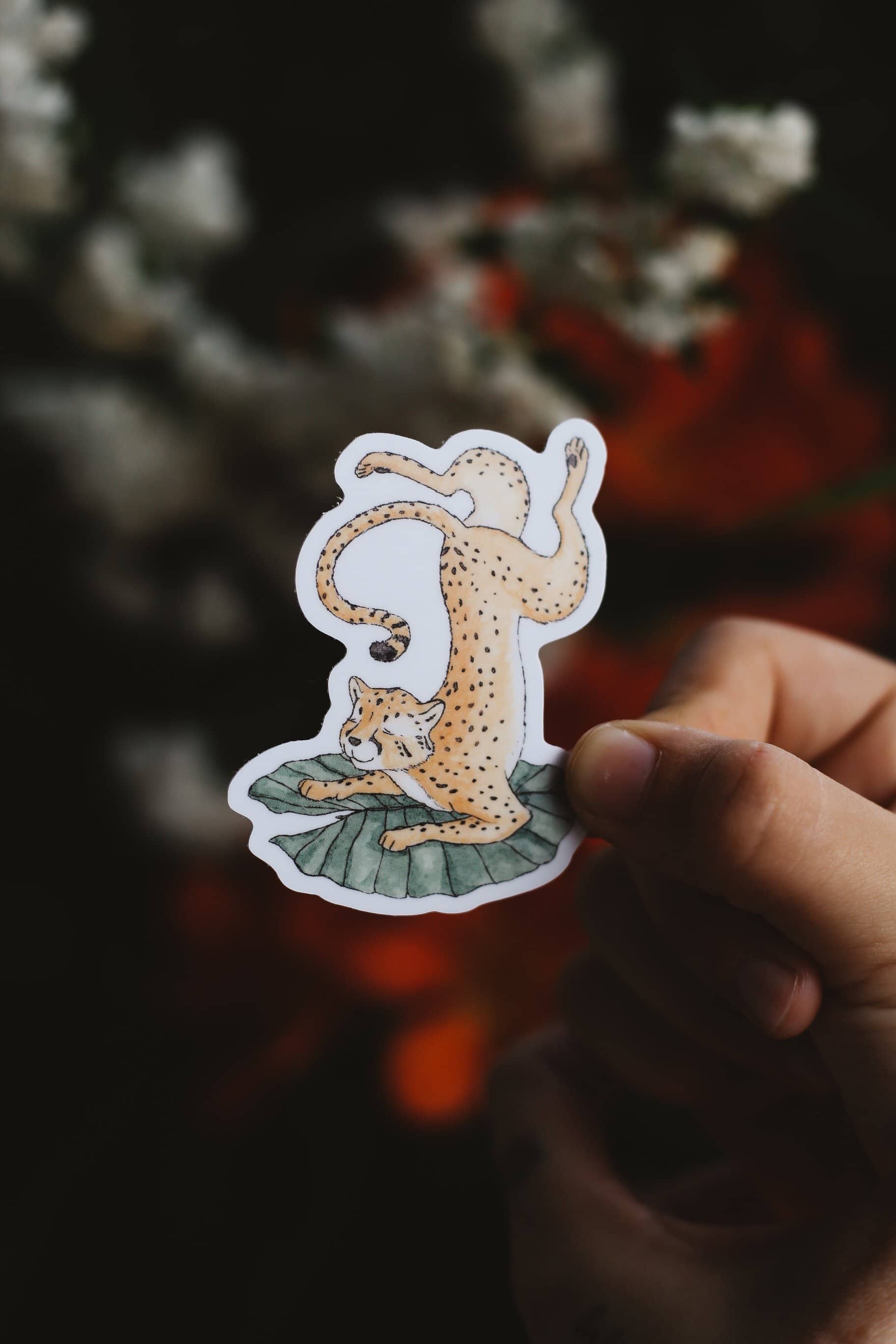 Hand holding a sticker of a cheetah on a lilypad