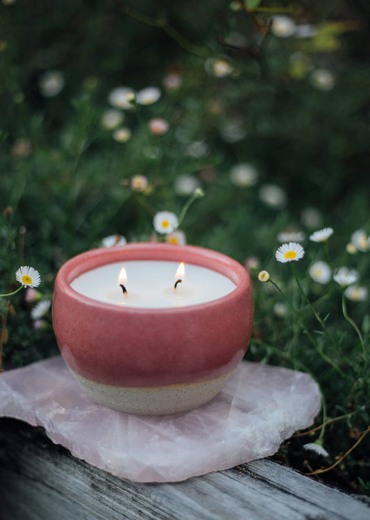 Àine & Co. Comfort Candle Cup in Bácáil (Fire). A reusable ceramic candle cup featuring a deep pink colour. Filled with a candle with two wicks.