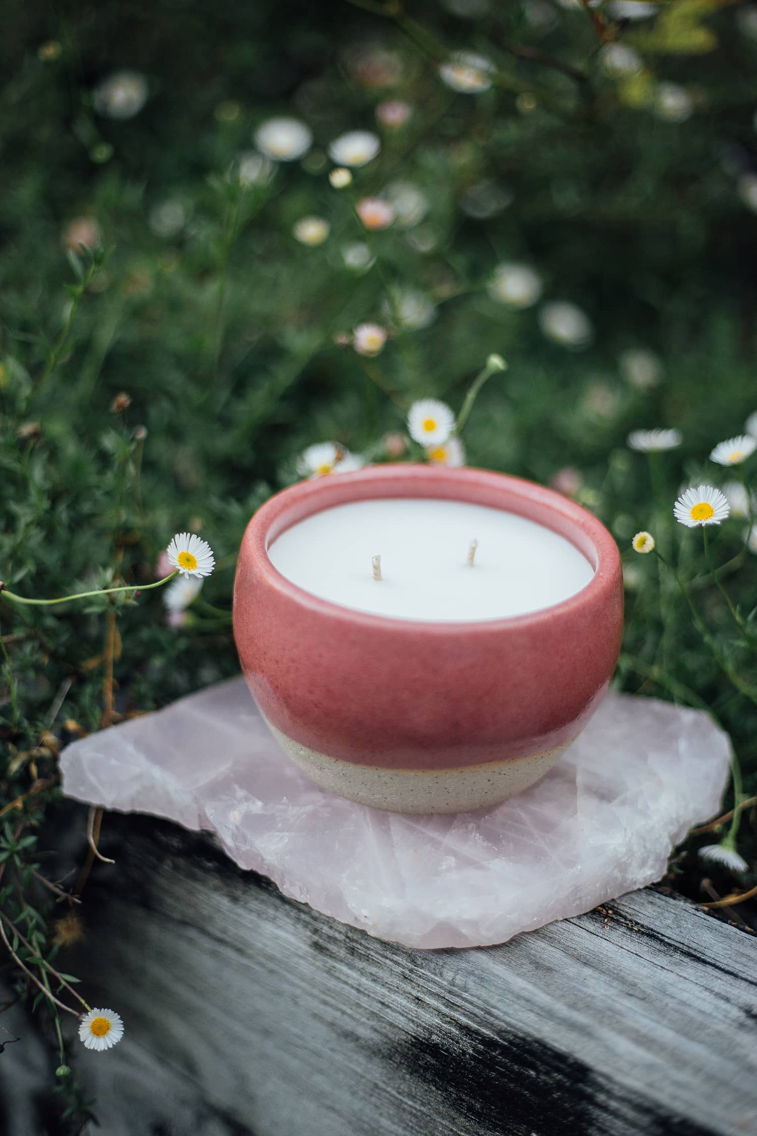 Àine & Co. Comfort Candle Cup in Bácáil (Fire). A reusable ceramic candle cup featuring a deep pink colour. Filled with a candle with two wicks.