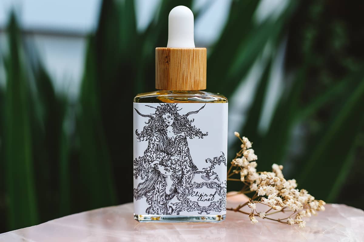 Elixir of Áine – Pure, Natural Hair Oil, packaged in glass dripper bottle with intricate illustration of the Goddess Àine