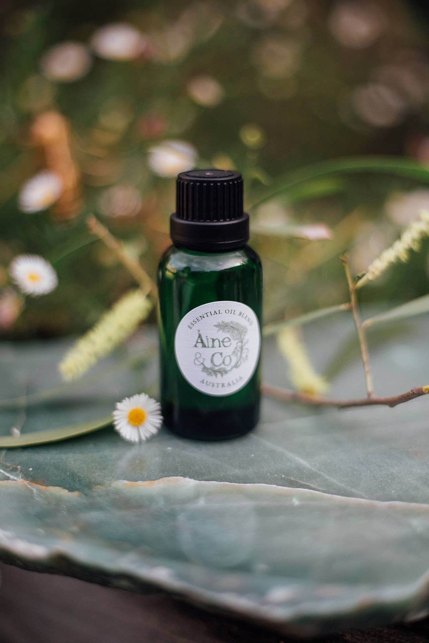 Àine & Co. Essential Oil Blend in the scent Australia in a small green dropper bottle with a black cap