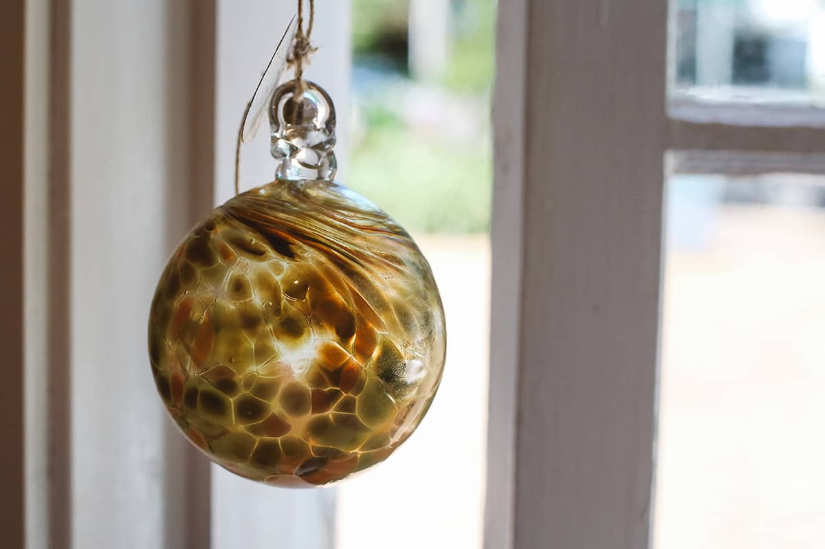 Àine & Co. Faerie Glass Bauble in style "G", featuring green and orange glass design