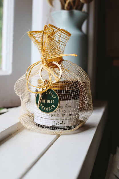 Àine & Co. yellow Sinamay mesh gift bag, paired with Alphabet Bags metal keyring in "Officially The Best Teacher" and custom candle inside