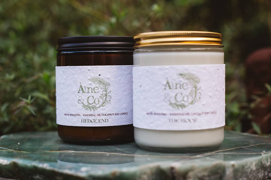 Àine & Co Candle Jar in Hedge End, packaged in an amber glass jar with a black lid, next to The Moor candle jar