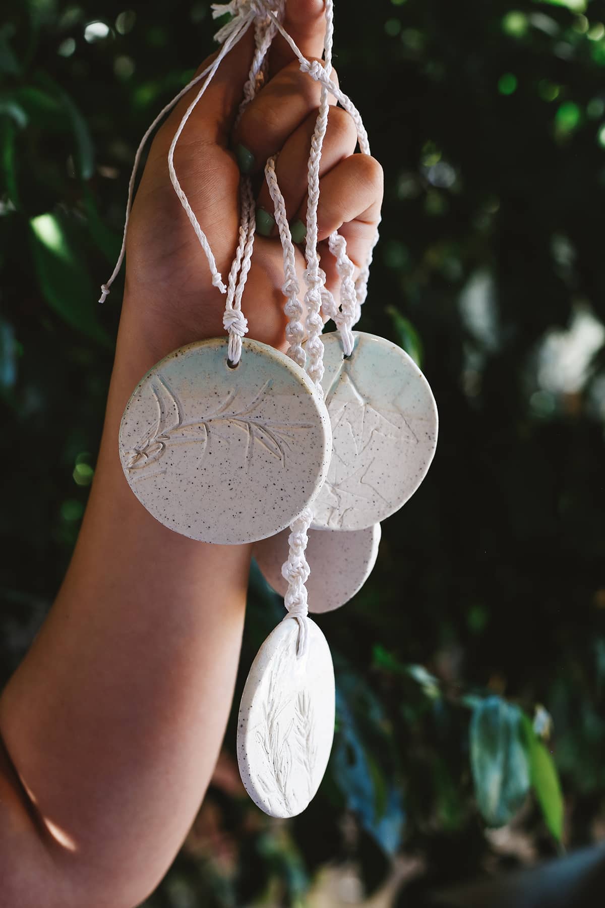 Àine & Co. Handmade Ceramic Car Diffusers in botanical disk style featuring woven string