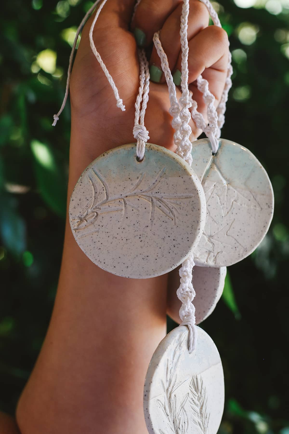 Àine & Co. Handmade Ceramic Car Diffusers in botanical disk style featuring woven string