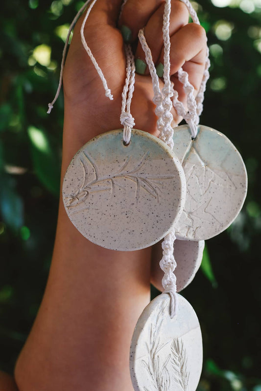 Àine & Co. Handmade Ceramic Car Diffusers in botanical disk style featuring woven string