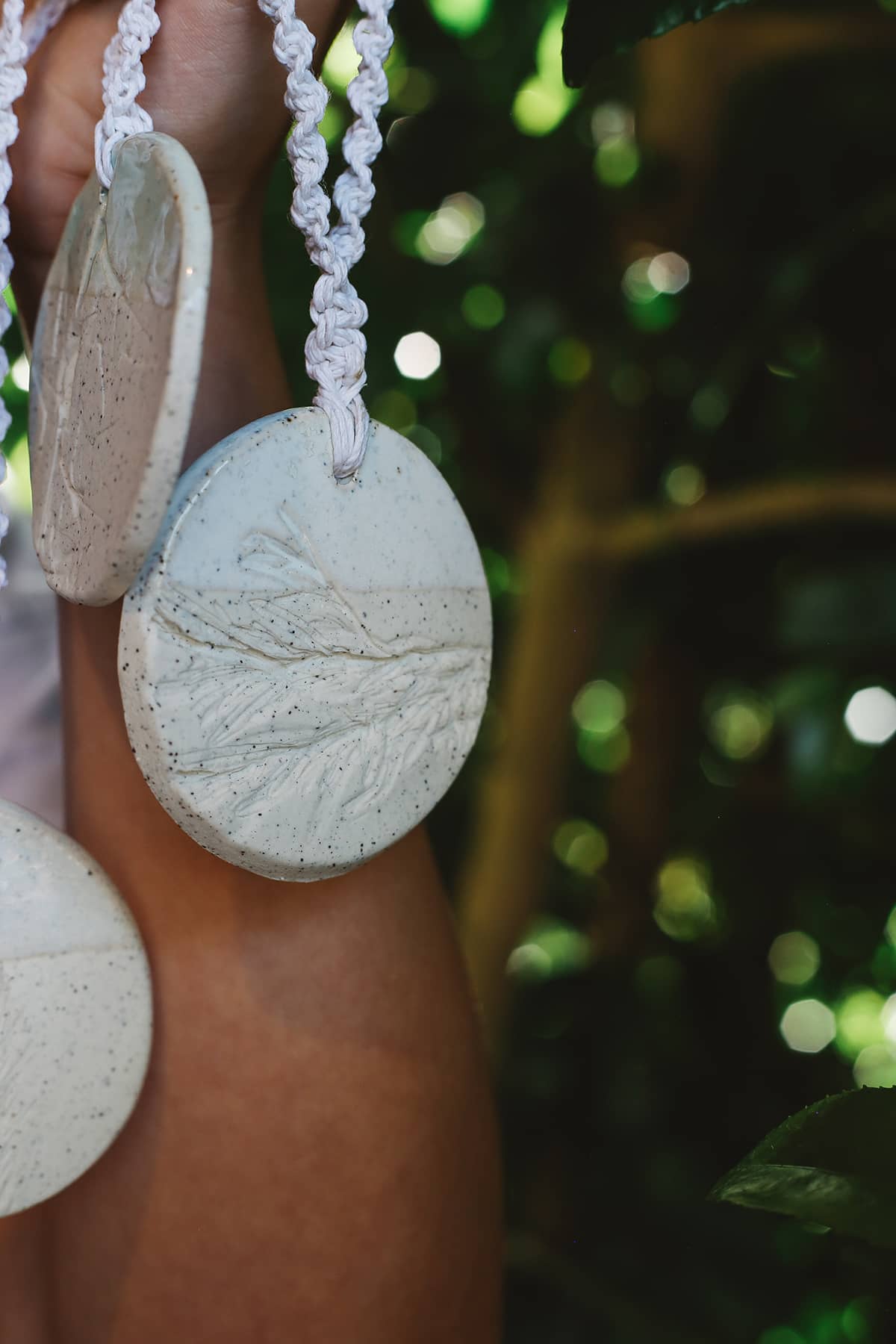 Àine & Co. Handmade Ceramic Car Diffusers in botanical disk style featuring woven string