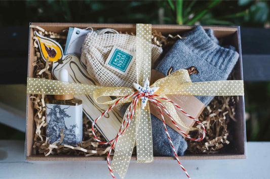 Gift box with socks, a candle, and other items on a blurred background