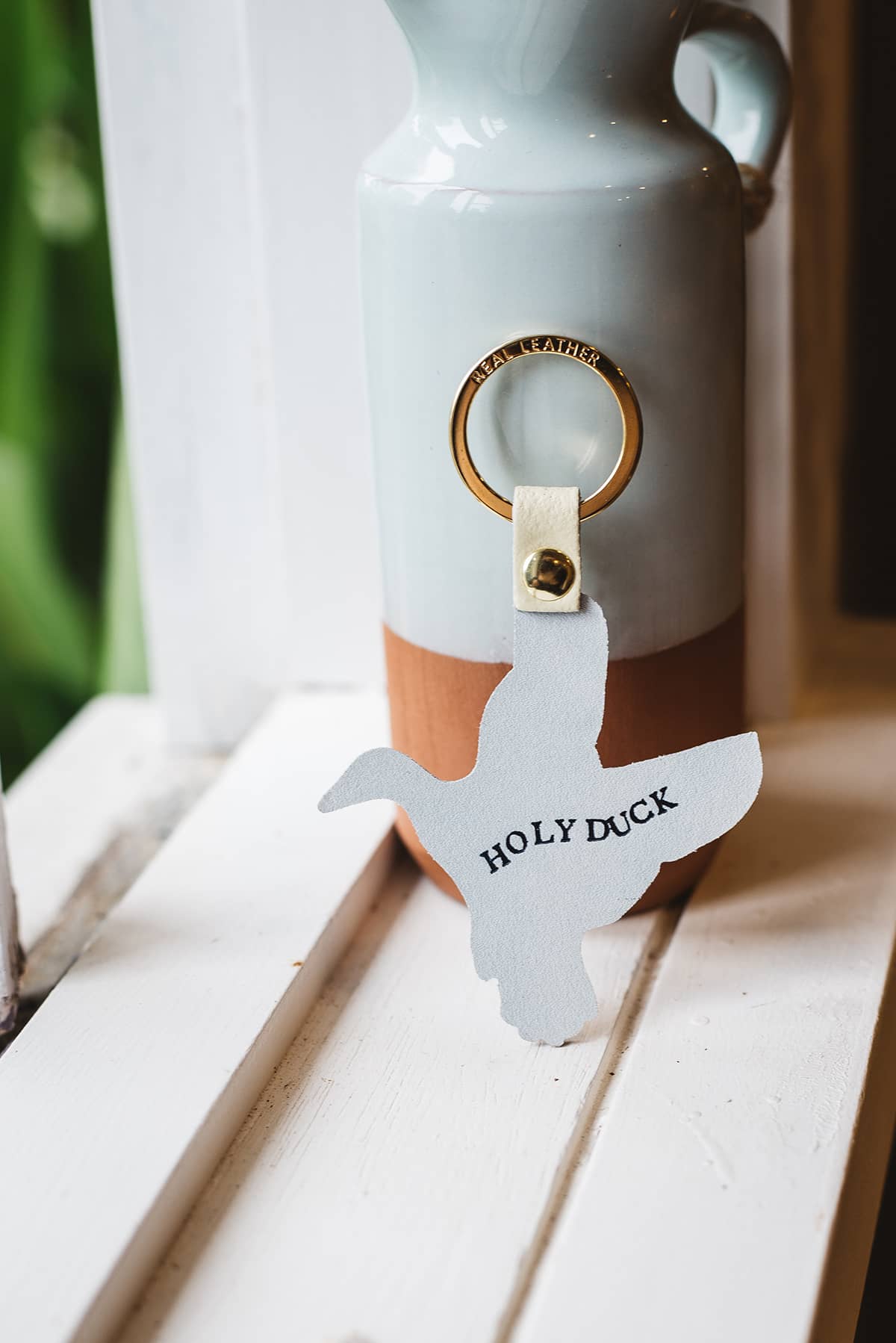 Back of Àine & Co. Ark Colour Design Keyring in "Duck", featuring leather duck design and gold hardware with text "Holy Duck"