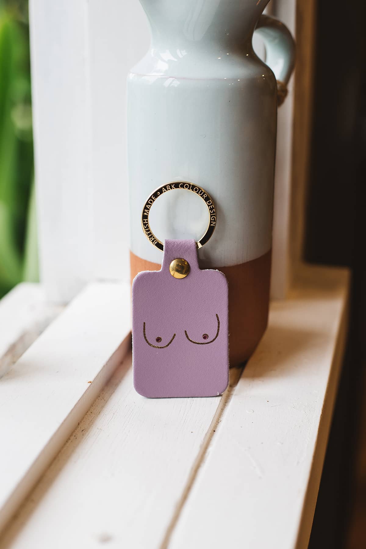 Àine & Co. Ark Colour Design Keyring in "Female (Purple)", featuring leather with illustrated breast design and gold hardware
