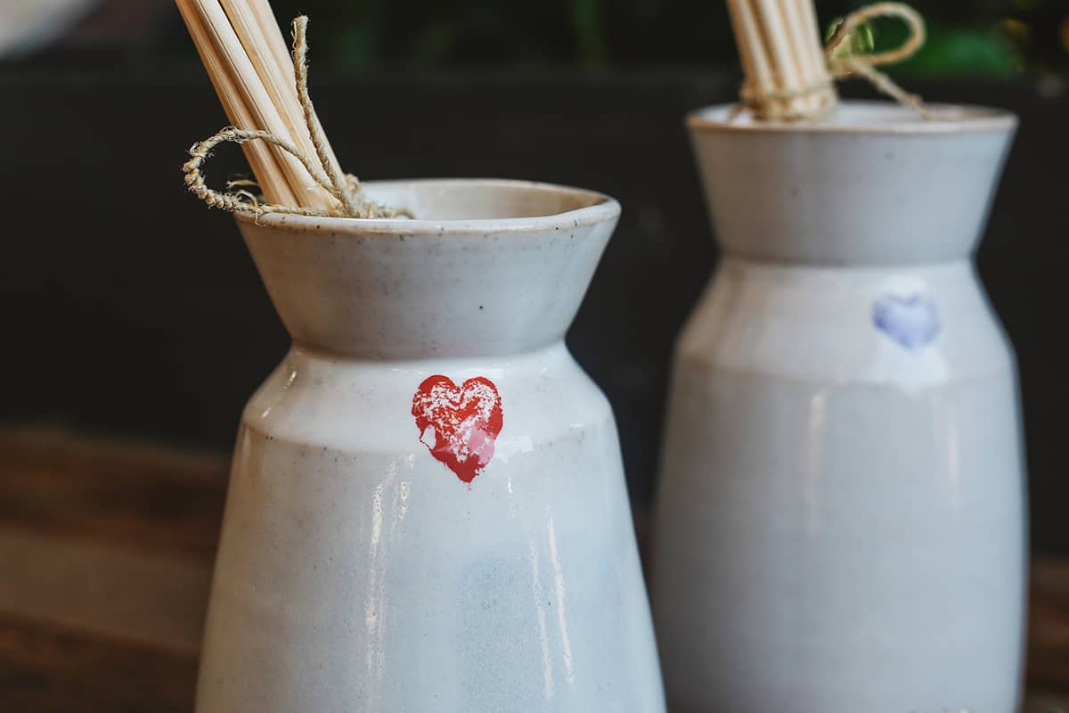 Close up shot of Àine & Co. Love in Bloom Ceramic Reed Diffuser and vase, featuring a painted heart shape.