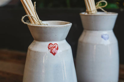 Close up shot of Àine & Co. Love in Bloom Ceramic Reed Diffuser and vase, featuring a painted heart shape.
