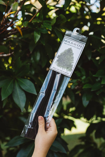 Hand holding one pack of 15 Àine & Co. Moldevite Incense Sticks