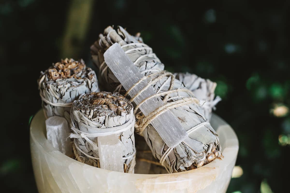 Close-up shot of Àine & Co.'s Selenite & White Sage Cleansing Sticks in a crystal bowl