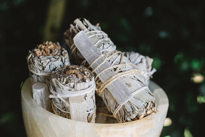 Close-up shot of Àine & Co.'s Selenite & White Sage Cleansing Sticks in a crystal bowl