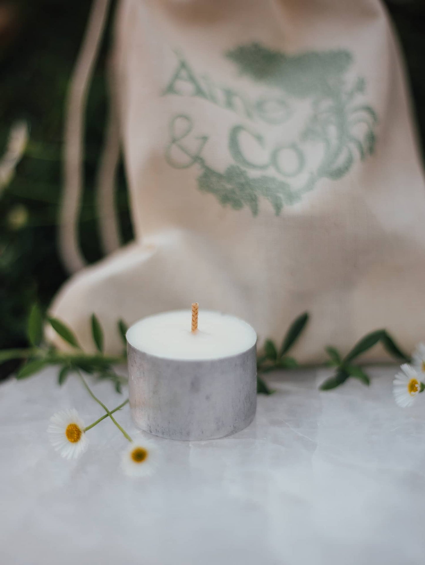An Àine & Co. Tea Light, shown with the Àine & Co. calico drawstring bag
