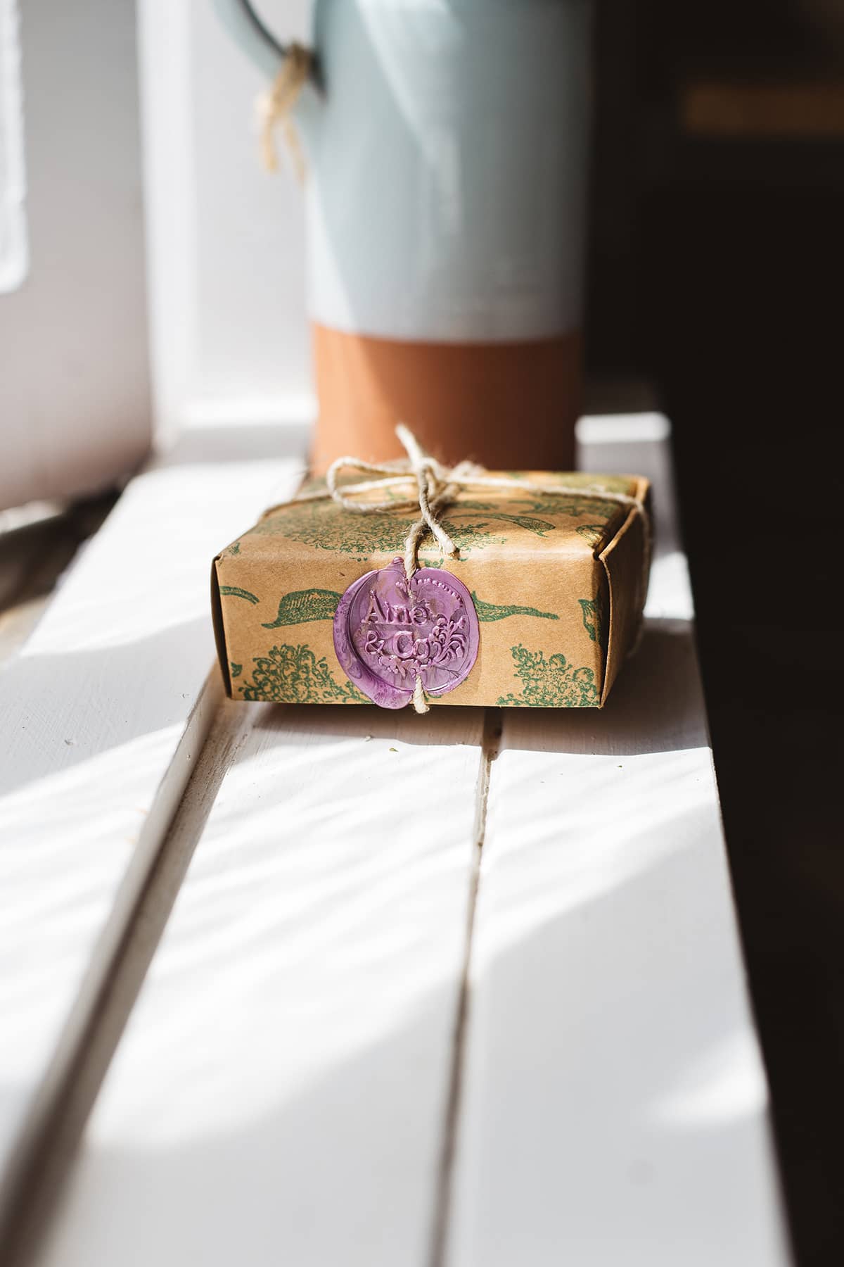 Àine & Co. small wax melt box in The Calm, packaged in illustrated paper box, wrapped in string, sealed with lilac logo wax seal