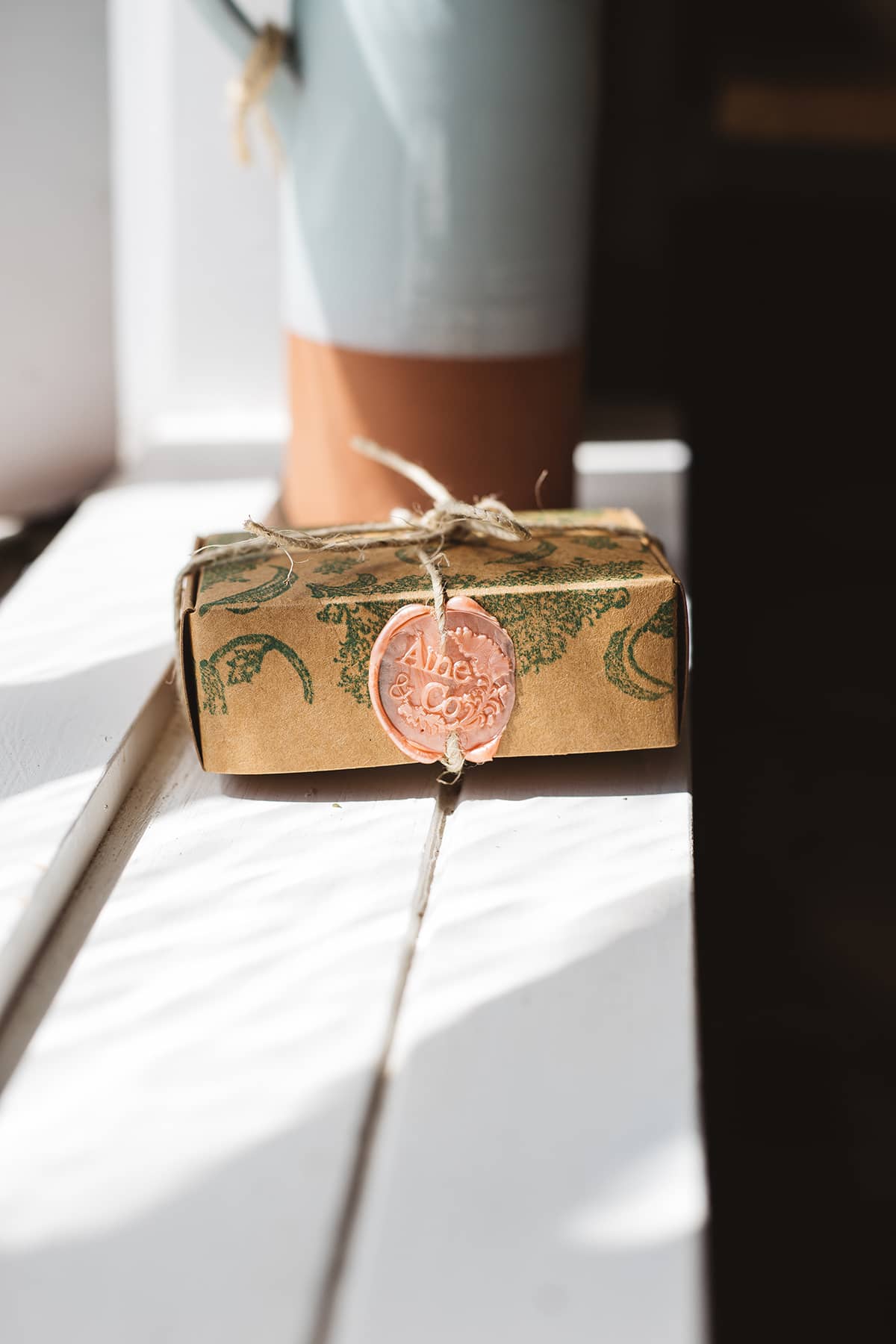 Àine & Co. small wax melt box in La Na Maithreacha, packaged in illustrated paper box, wrapped in string, sealed with coral logo wax seal