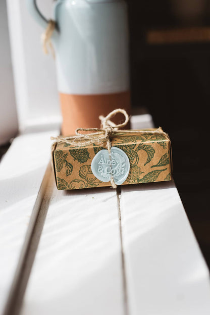 Àine & Co. small wax melt box in The Moor, packaged in illustrated paper box, wrapped in string, sealed with mint logo wax seal