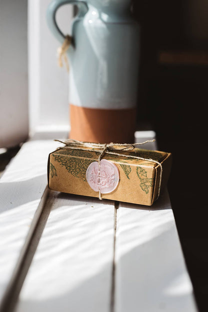 Àine & Co. small wax melt box in Slainte, packaged in illustrated paper box, wrapped in string, sealed with pastel pink logo wax seal